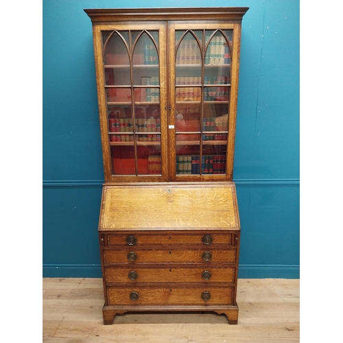 397 - Georgian oak bureau bookcase with fitted red velvet interior on bracket feet above two glazed doors.... 