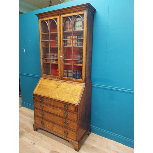 397 - Georgian oak bureau bookcase with fitted red velvet interior on bracket feet above two glazed doors.... 