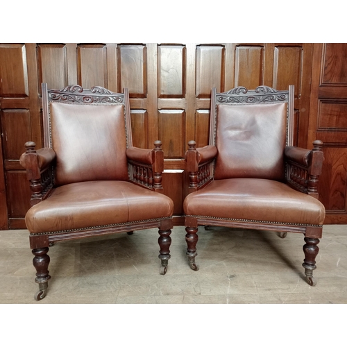 470 - Pair of oak fireside chairs with tan leather on turned front legs with castors {H 105cm x W 66cm x D... 