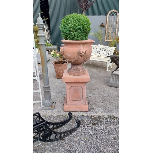 708 - Pair of good quality moulded terracotta urns decorated with lions masks and swags raised on pedestal... 