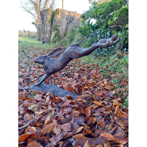 751 - Exceptional quality bronze sculpture of a leaping hare {58cm H x 100cm W x 30cm D}