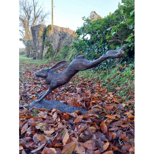 751 - Exceptional quality bronze sculpture of a leaping hare {58cm H x 100cm W x 30cm D}