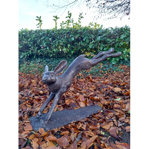 751 - Exceptional quality bronze sculpture of a leaping hare {58cm H x 100cm W x 30cm D}