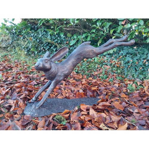 751 - Exceptional quality bronze sculpture of a leaping hare {58cm H x 100cm W x 30cm D}