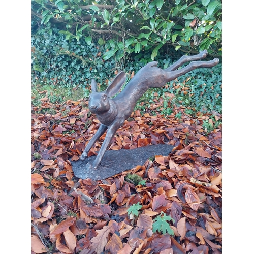 751 - Exceptional quality bronze sculpture of a leaping hare {58cm H x 100cm W x 30cm D}