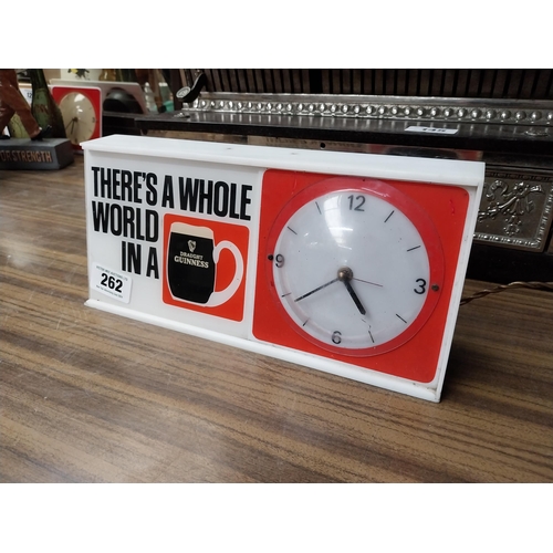 262 - There's a whole world in Guinness Perspex battery advertising clock. {15 cm H x 32 cm W x 8 cm D}.