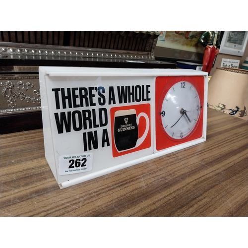 262 - There's a whole world in Guinness Perspex battery advertising clock. {15 cm H x 32 cm W x 8 cm D}.