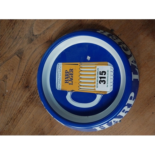 315 - Two tin plate Harp Lager advertising ashtrays. {3 cm H x 20 cm Dia.}.