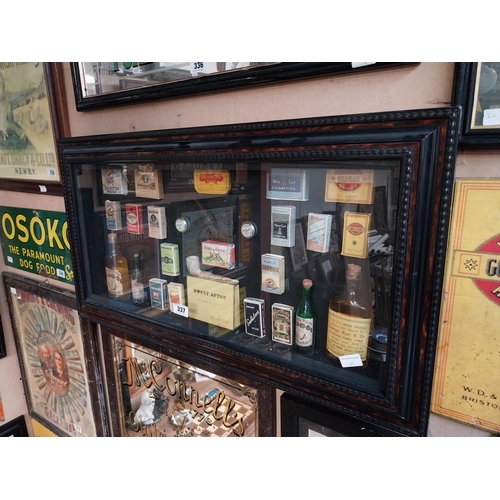 337 - Framed collage of Whiskey bottles, Cigarettes boxes and pipes etc. {51 cm H x 96 cm W}.