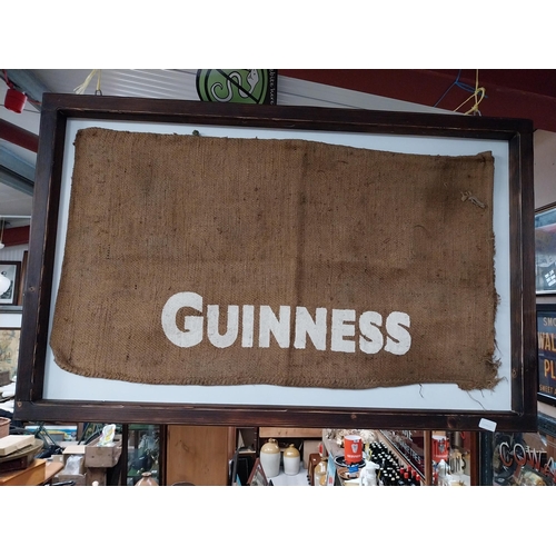 408 - Guinness sack cloth mounted on wooden frame. {76 cm x 115 cm W