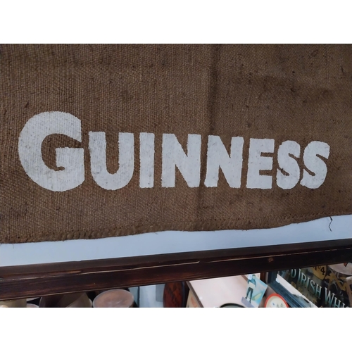 408 - Guinness sack cloth mounted on wooden frame. {76 cm x 115 cm W