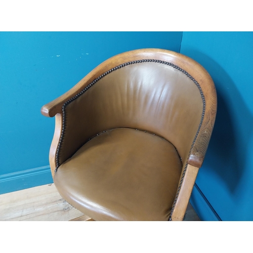 238 - 1940s oak and leather swivel office chair raised on four outswet legs and castors {83 cm H x 52 cm W... 