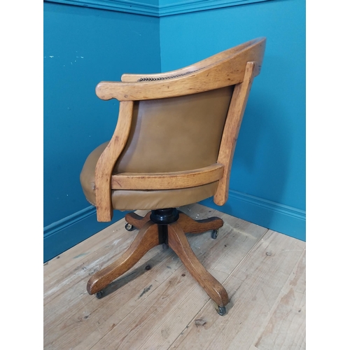 238 - 1940s oak and leather swivel office chair raised on four outswet legs and castors {83 cm H x 52 cm W... 