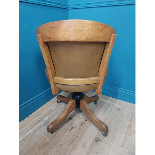 238 - 1940s oak and leather swivel office chair raised on four outswet legs and castors {83 cm H x 52 cm W... 