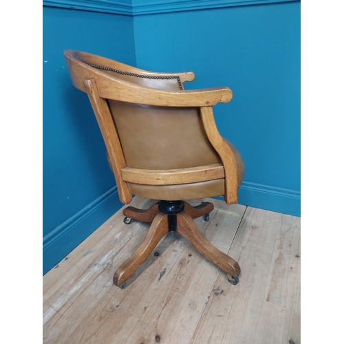 238 - 1940s oak and leather swivel office chair raised on four outswet legs and castors {83 cm H x 52 cm W... 