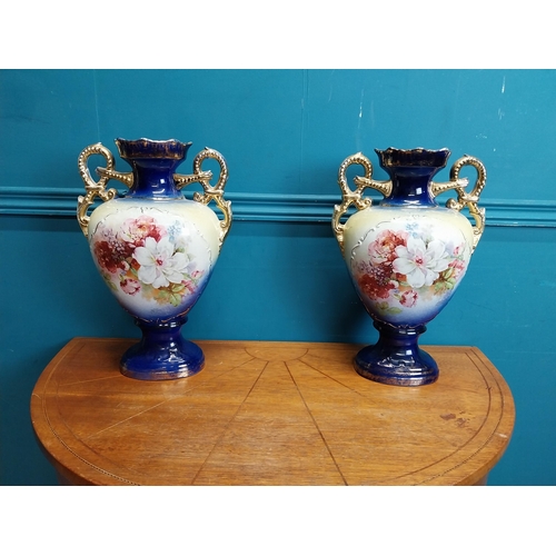 638 - Pair of ceramic vases with floral design and gilt handles {35 cm H x 24 cm W x 15 cm D}.