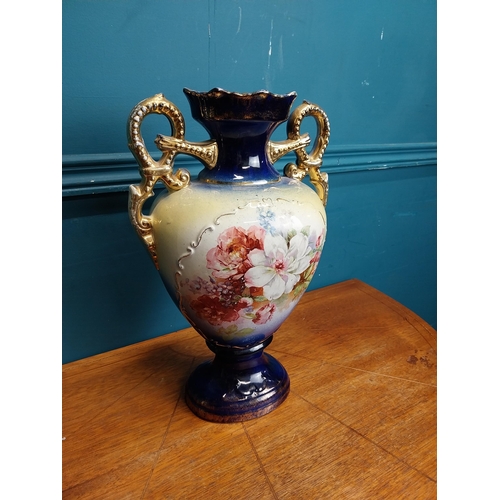 638 - Pair of ceramic vases with floral design and gilt handles {35 cm H x 24 cm W x 15 cm D}.