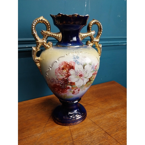638 - Pair of ceramic vases with floral design and gilt handles {35 cm H x 24 cm W x 15 cm D}.