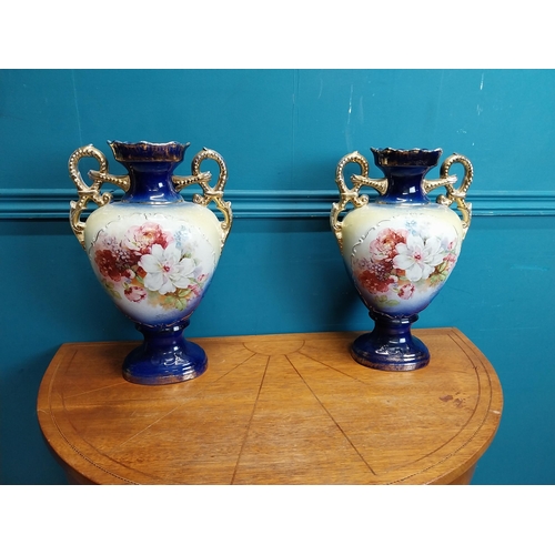 638 - Pair of ceramic vases with floral design and gilt handles {35 cm H x 24 cm W x 15 cm D}.