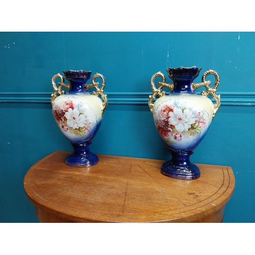 638 - Pair of ceramic vases with floral design and gilt handles {35 cm H x 24 cm W x 15 cm D}.