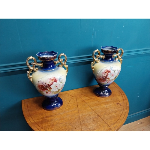 638 - Pair of ceramic vases with floral design and gilt handles {35 cm H x 24 cm W x 15 cm D}.