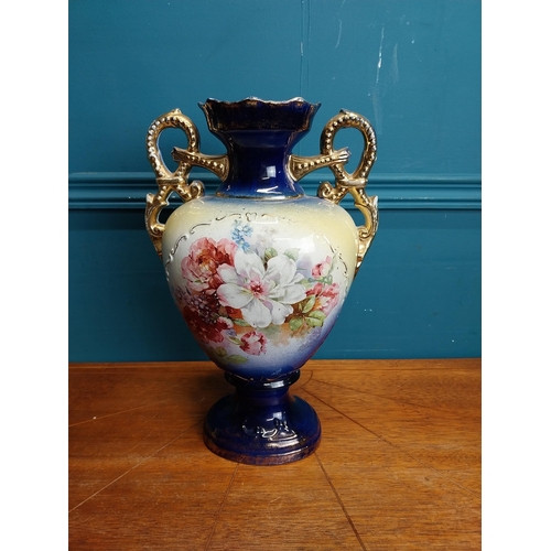 638 - Pair of ceramic vases with floral design and gilt handles {35 cm H x 24 cm W x 15 cm D}.