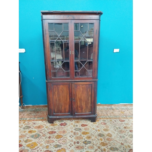 766 - Georgian mahogany corner cupboard the two astragal glazed doors over two blind doors raised on brack... 