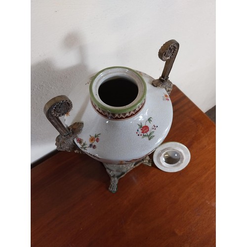 112 - Decorative ceramic and gilded metal lidded urn decorated with cherubs and floral gardlands.  {45 cm ... 