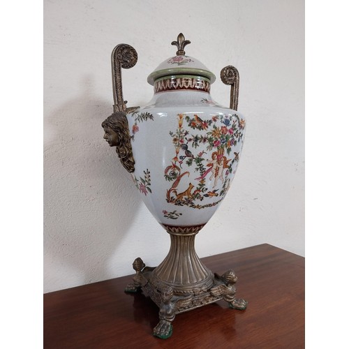 112 - Decorative ceramic and gilded metal lidded urn decorated with cherubs and floral gardlands.  {45 cm ... 