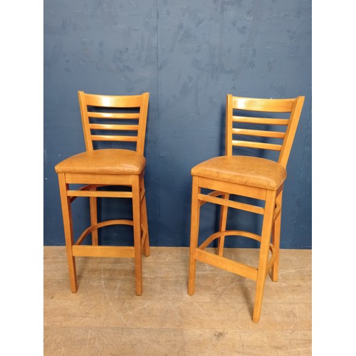 876 - Pair of breakfast bar stools raised on three legs. { 94cm H X 52cm W X 50cm D }.