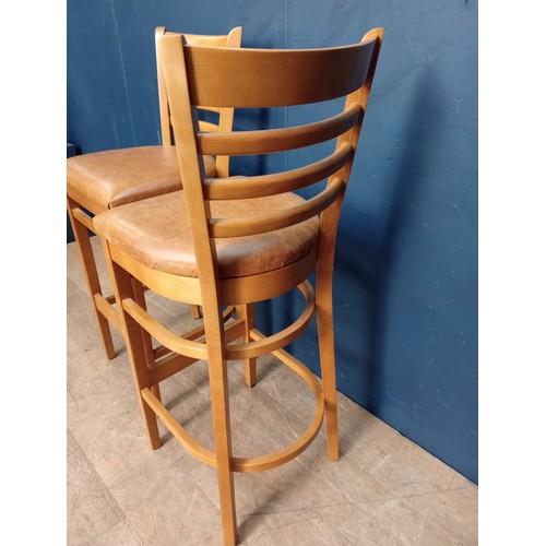 876 - Pair of breakfast bar stools raised on three legs. { 94cm H X 52cm W X 50cm D }.