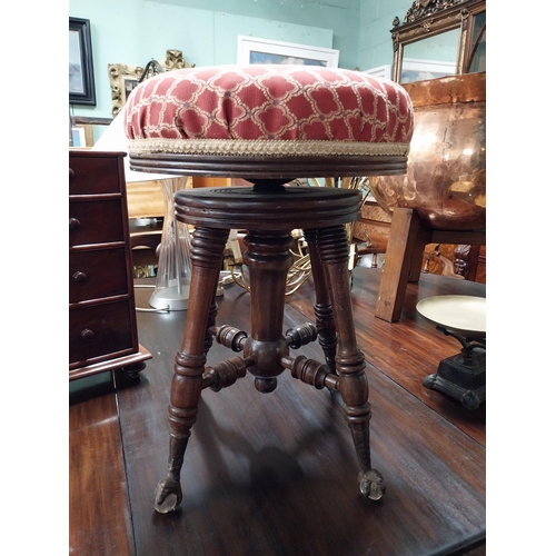 945 - 19th. C. revolving piano stool with upholstered seat raised on turned legs and claw feet.with glass ... 