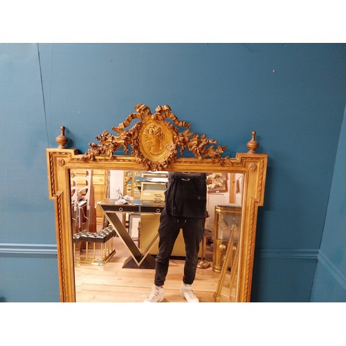 206 - 19th C. French gilt mirror with floral decoration surmounted with female mask and bows. {168 cm H x ... 