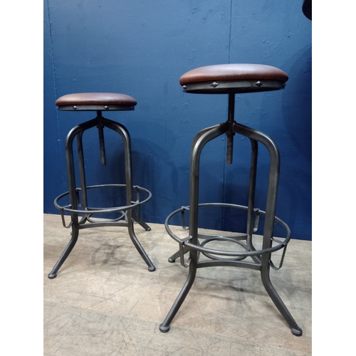 975 - Pair of metal industrial stools with leather upholstered seats. { 78cm H X 35cm Dia }.