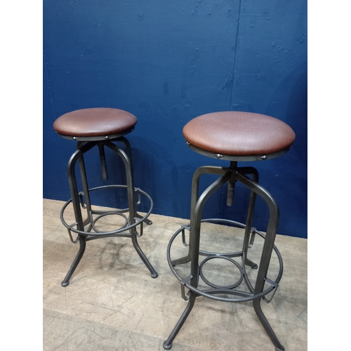 975 - Pair of metal industrial stools with leather upholstered seats. { 78cm H X 35cm Dia }.