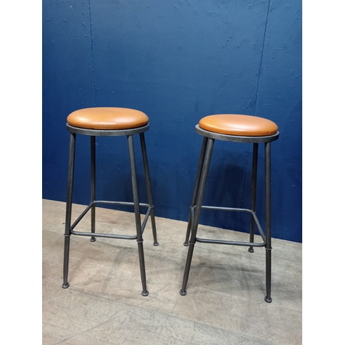 977 - Pair of metal industrial stools with leather upholstered seats. { 78cm H X 35cm Dia }.