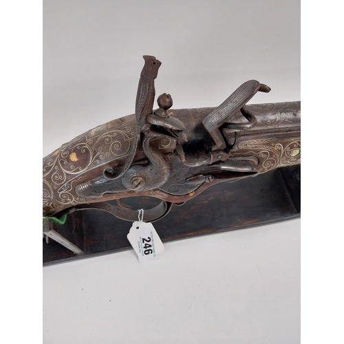 246 - Turkish flintlock blunderbuss inlaid with silver and mother of pearl on stand. {88 cm L x 18 cm W}.