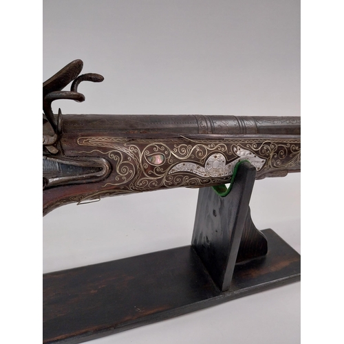 246 - Turkish flintlock blunderbuss inlaid with silver and mother of pearl on stand. {88 cm L x 18 cm W}.