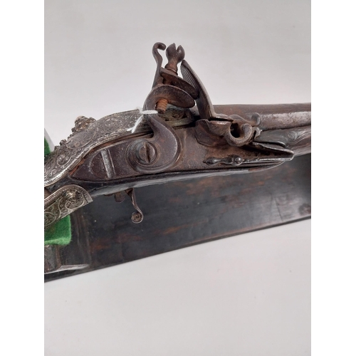 252 - Turkish flintlock pistol decorated with ornate white metal mounts. { 50cm L overall. }.