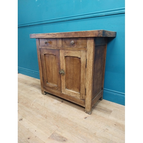 54 - Early 20th C. oak and pine cupboard with two long doors over two short drawers on square feet. {80 c... 