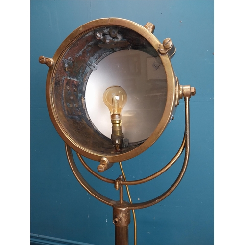 57 - Early 20th C. brass search light on cast iron base. {186 cm H x 50 cm W x 50 cm D].