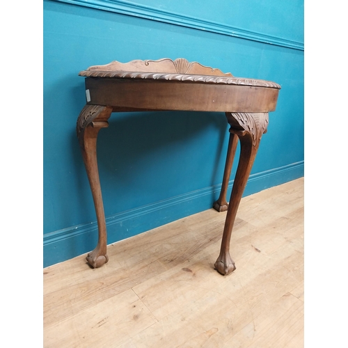 85 - 1950's mahogany demi lune table with carved frieze on the claw and ball feet. {83 cm H x 90 cm W x 4... 