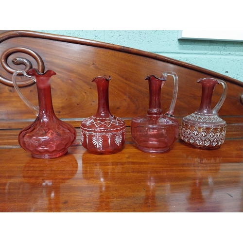 919 - Four 19th C. ruby glass jugs. {22 cm H}.