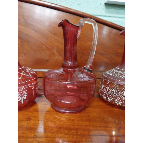 919 - Four 19th C. ruby glass jugs. {22 cm H}.