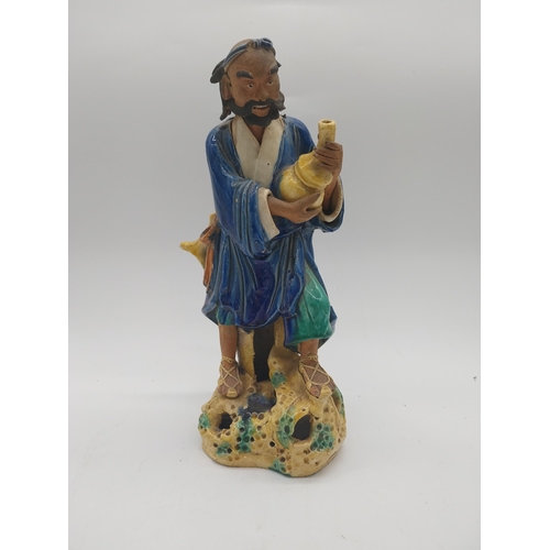 958 - Glazed oriental figure of Water Carrier. {32 cm H x 16 cm W x 13 cm D}.