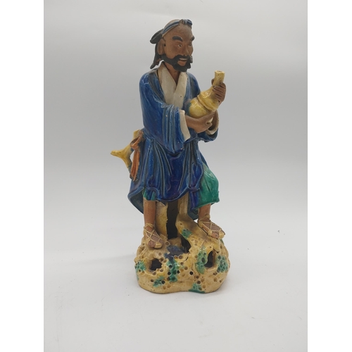 958 - Glazed oriental figure of Water Carrier. {32 cm H x 16 cm W x 13 cm D}.