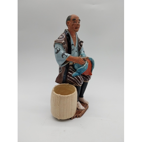 998 - Glazed stoneware Oriental figure of a Fruit Picker. {23 cm H x 14 cm D x 9 cm D}.