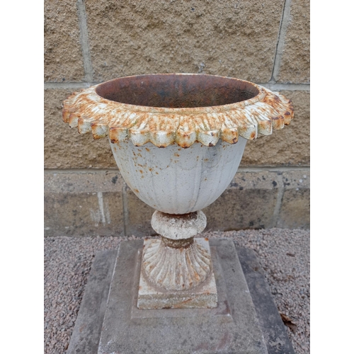 21 - Cast iron urn on stone base {H 50cm x W 43cm x D 43cm }. (NOT AVAILABLE TO VIEW IN PERSON)