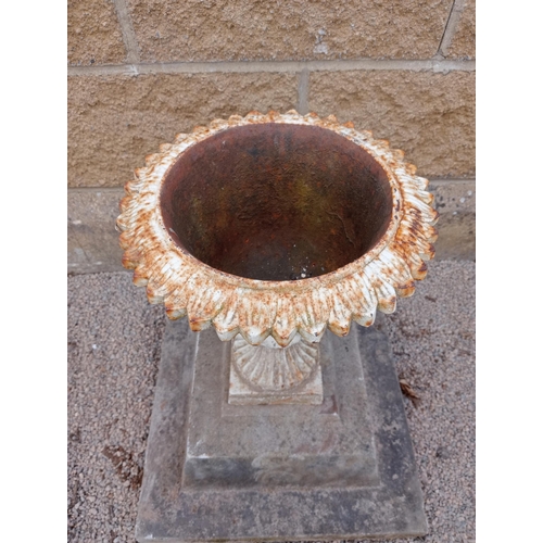 21 - Cast iron urn on stone base {H 50cm x W 43cm x D 43cm }. (NOT AVAILABLE TO VIEW IN PERSON)