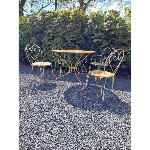 264 - Early 20th C. French wrought iron garden table with three matching chairs and one matching armchair ... 